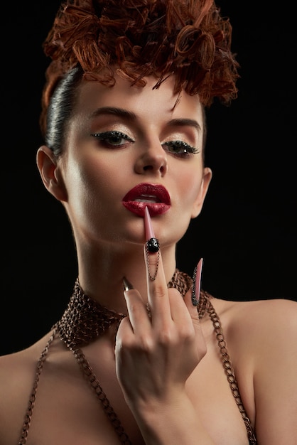 Donna affascinante che indossa trucco e nailart alla moda