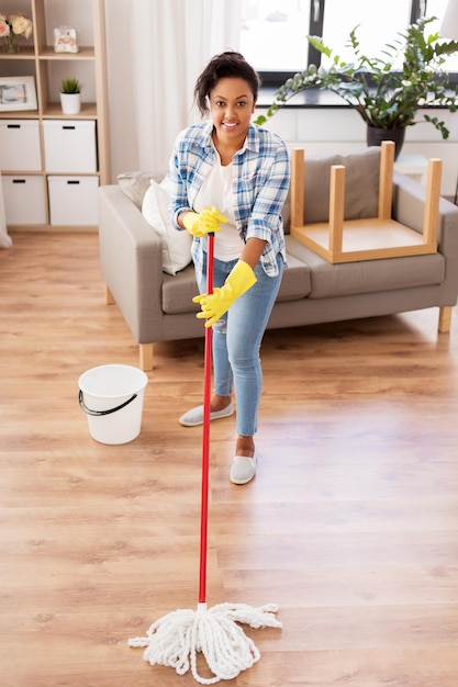 donna africana o casalinga che pulisce il pavimento a casa