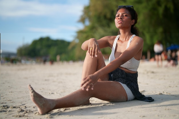 Donna africana sedersi sulla spiaggia Ritratto sexy signora africana viaggiare ping e rilassarsi in estate con la natura tropicale