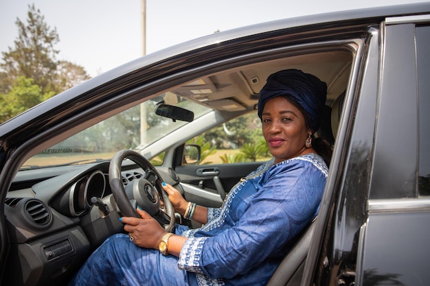 Donna africana seduta all'interno dell'auto con le mani che afferrano il volante