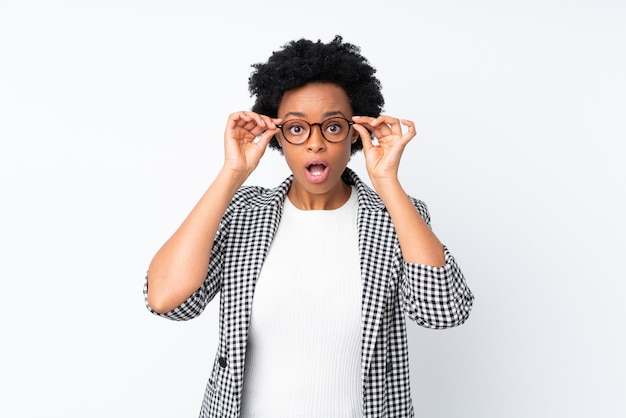 Donna afro-americana con blazer isolato con gli occhiali e sorpreso