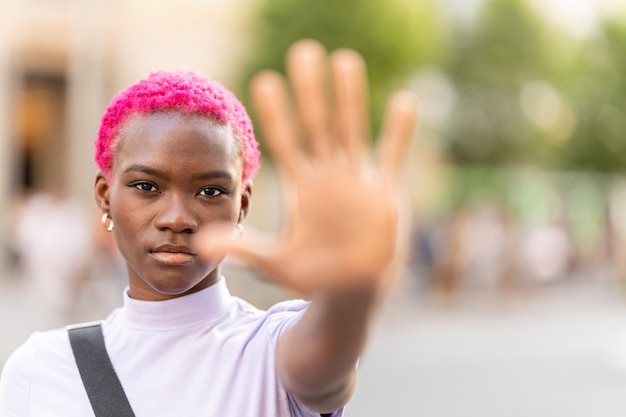 Donna afro che gesturing fermata con la mano all'aperto