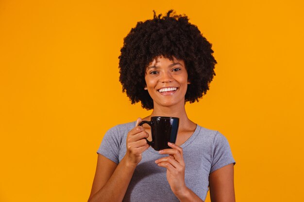 Donna afro che prende il tè sul giallo