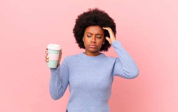 Donna afro che si sente perplessa e confusa, si gratta la testa e guarda di lato. concetto di caffè