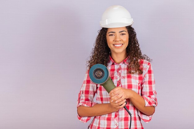 Donna afro che tiene una levigatrice elettrica. concetto di materiale da costruzione