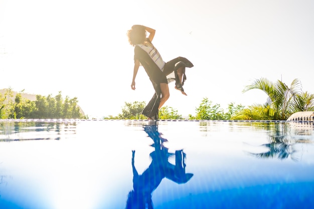 Donna afro con abito accanto a una piscina