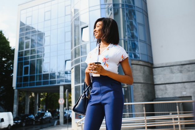 Donna afro con caffè per andare