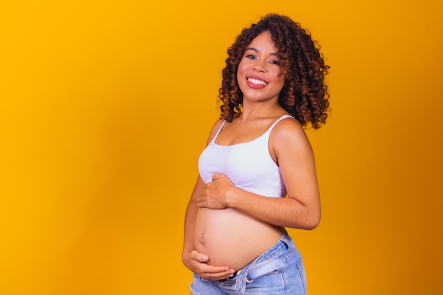 Donna afro incinta su sfondo giallo