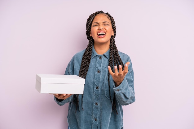 Donna afro nera che sembra disperata, frustrata e stressata, concetto di scatola di pacchetti