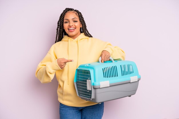 Donna afro nera che sembra eccitata e sorpresa che indica il concetto di contenitore da viaggio per animali domestici laterale