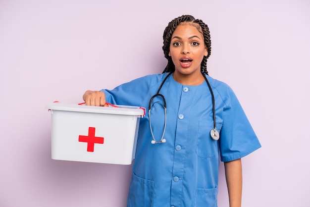 donna afro nera che sembra molto scioccata o sorpresa. concetto di infermiere e kit di pronto soccorso