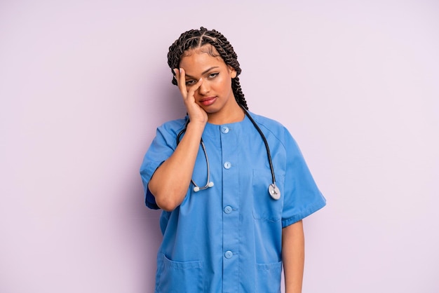 Donna afro nera che si sente annoiata, frustrata e assonnata dopo un noioso concetto di infermiera