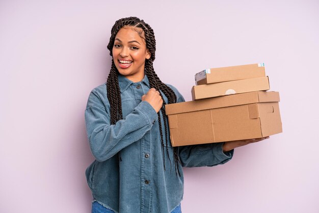 Donna afro nera che si sente felice e affronta una sfida o festeggia. concetto di scatola di pacchetti