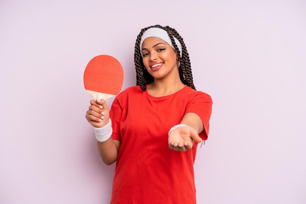 Donna afro nera che sorride felicemente con amichevole e offrendo e mostrando un concetto. concetto di ping pong