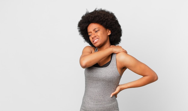 Donna afro nera sensazione di stanchezza stressata ansia frustrata e depressa sofferenza con dolore alla schiena o al collo