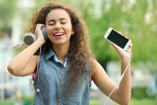 Donna afroamericana che ascolta musica in cuffia per strada