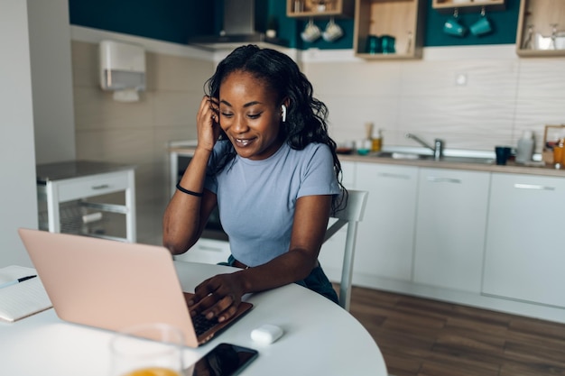 Donna afroamericana che lavora da casa mentre utilizza un computer portatile