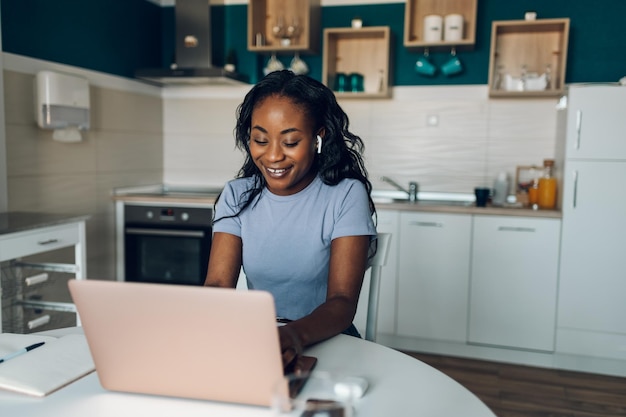 Donna afroamericana che lavora da casa mentre utilizza un computer portatile