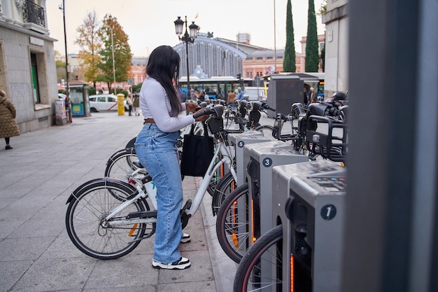 Donna afroamericana che noleggia una bicicletta tramite un'applicazione mobile