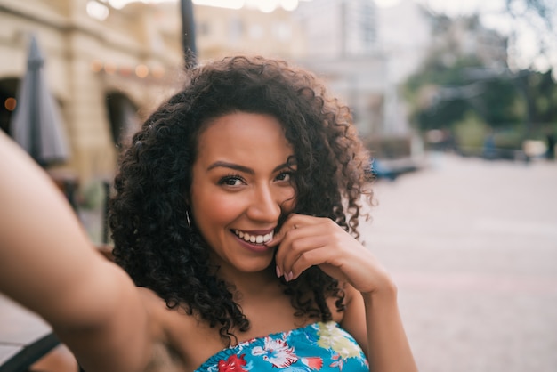 Donna afroamericana che prende un selfie nella città.