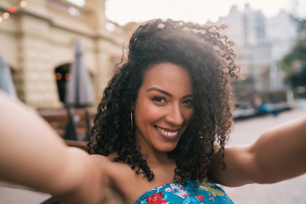 Donna afroamericana che prende un selfie nella città.