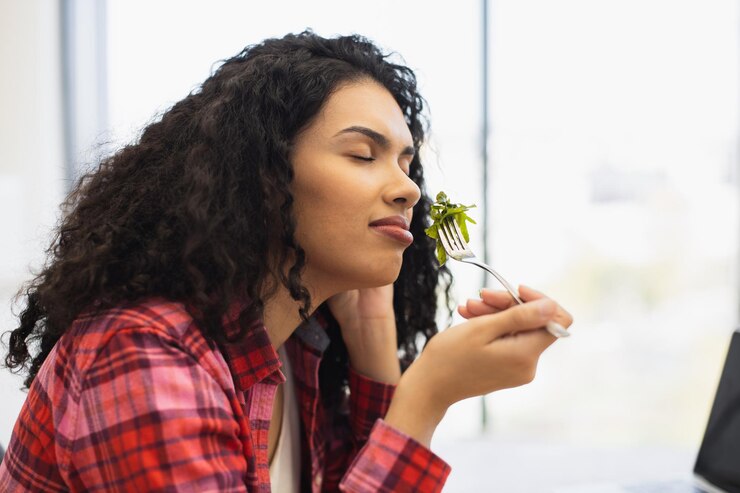 Foto donna afroamericana che si gode di un'insalata fresca in un ambiente interno luminoso
