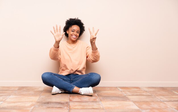 Donna afroamericana che si siede sul pavimento