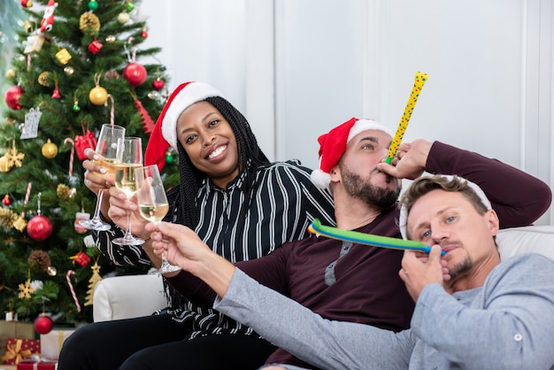 Donna afroamericana con il gruppo di amici che celebrano il Natale a casa