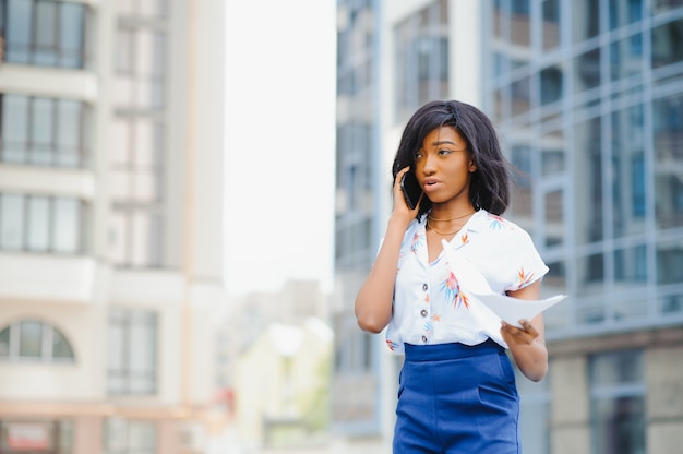 Donna afroamericana di affari che comunica su un telefono cellulare