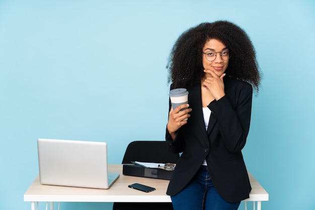 Donna afroamericana di affari che lavora nel suo pensiero sul posto di lavoro