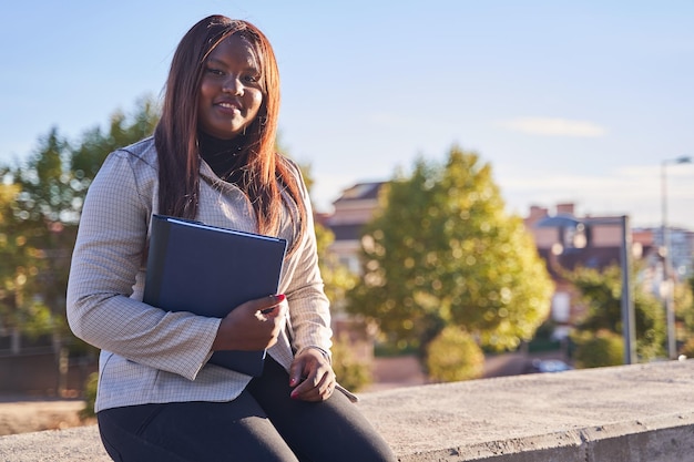 Donna afroamericana in cerca di lavoro e tiene una cartella con il suo CV