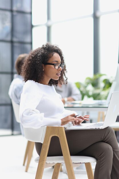 Donna afroamericana in ufficio seduto a un computer portatile