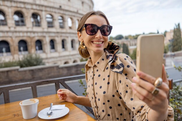 Donna al caffè all'aperto davanti al Colosseo a roma italia