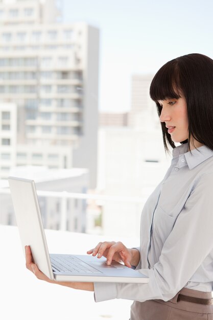 Donna al lavoro usando il suo computer portatile