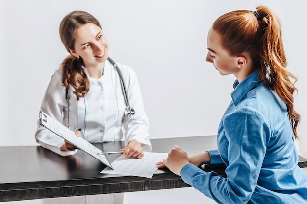 Donna al medico alla reception per controllare la salute al tavolo su sfondo bianco isolato