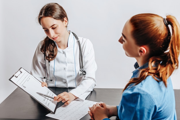 Donna al medico alla reception per controllare la salute al tavolo su uno spazio bianco isolato