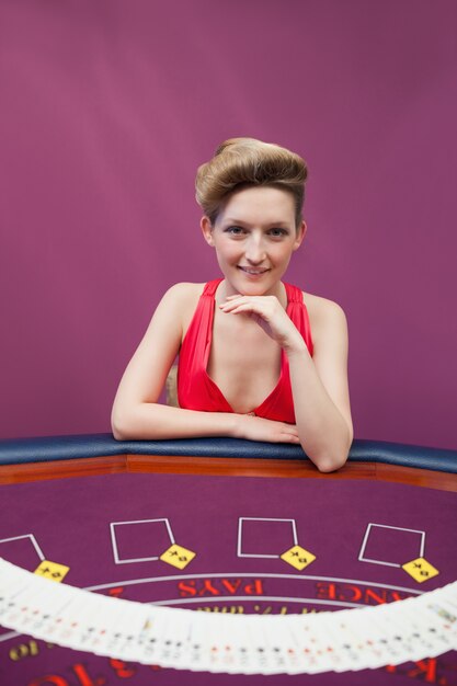 Donna al tavolo da poker con mazzo di diffusione