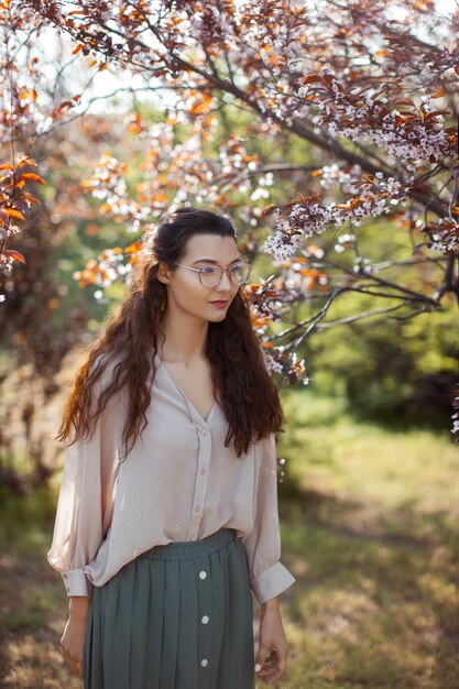 Donna all'aperto nel parco vicino all'albero del fiore della primavera