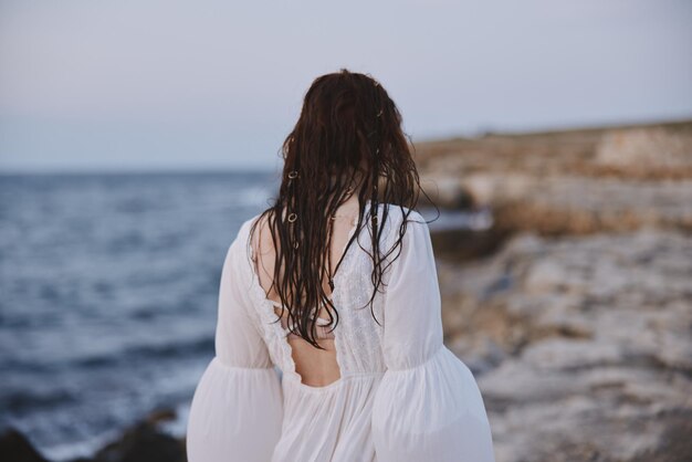 Donna all'aperto paesaggio oceano pietre viaggio inalterato