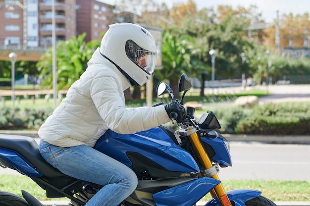 Donna alla guida di una motocicletta per la città