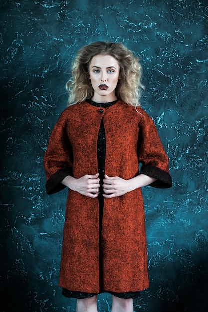 Donna alla moda alla moda vestita di un cappotto rosso