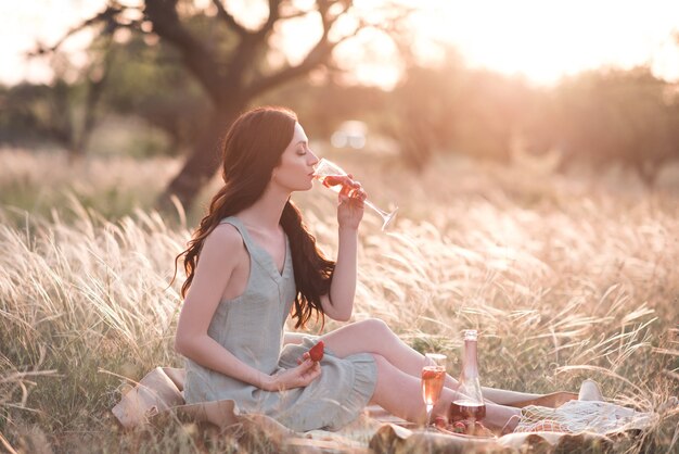 Donna alla moda che beve vino con fragola