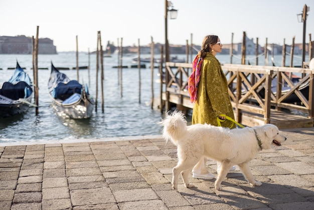 Donna alla moda che cammina con il cane a Venezia Italia