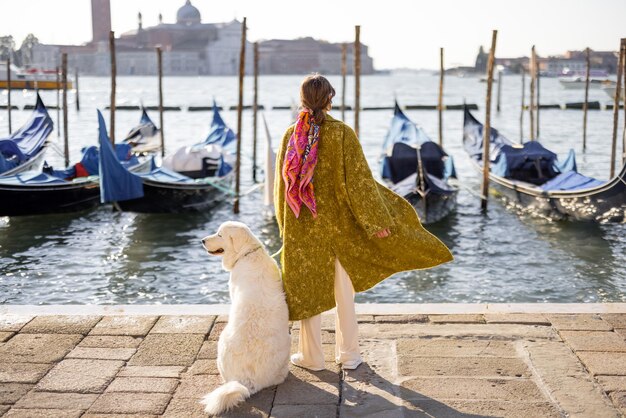 Donna alla moda che cammina con il cane a Venezia Italia