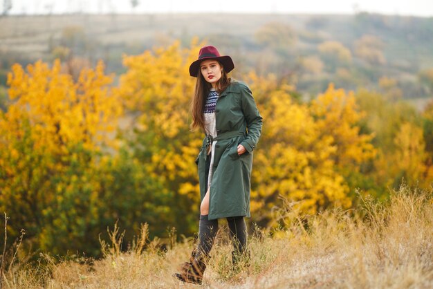 Donna alla moda che gode del tempo di autunno nel prato