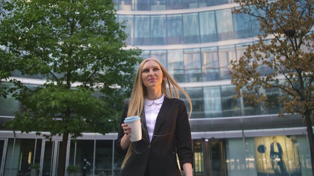 Donna alla moda di affari con caffè sulla strada.