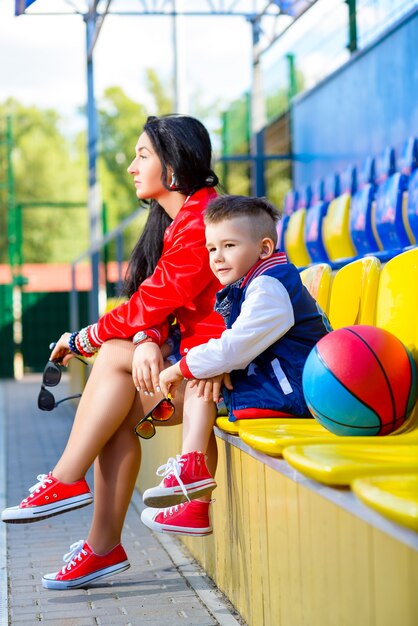 Donna alla moda e ragazzino in posa al campo da basket