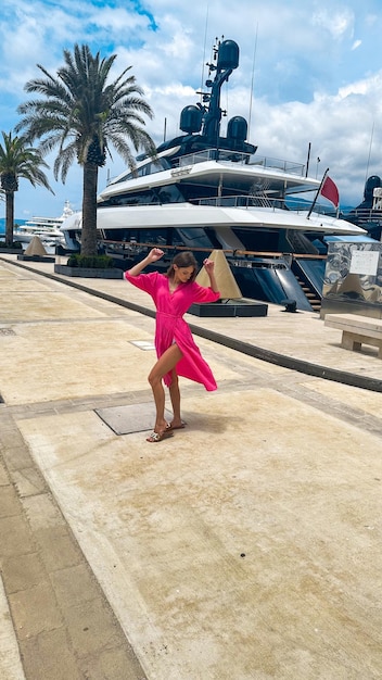 Donna alla moda in abito cammina sulla strada dello yacht