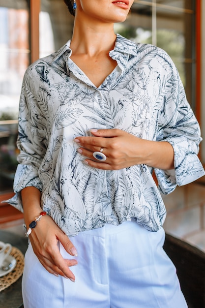 Donna alla moda in una camicia in un ristorante