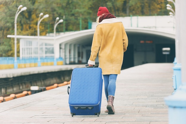 Donna alla stazione ferroviaria con una valigia